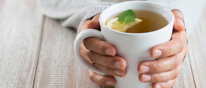 Woman's hand cradling cup of tea